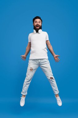 Neşeli adam atlama ve kamera bakıyor