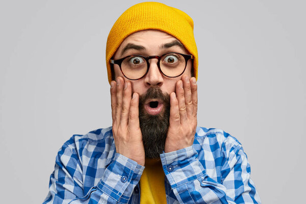 Shocked hipster looking at camera