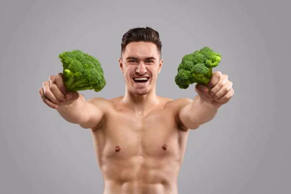 Atleta allegro mostrando broccoli — Foto Stock