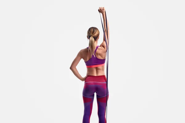 Unrecognizable athletic woman exercising with resistance band — Stock Photo, Image