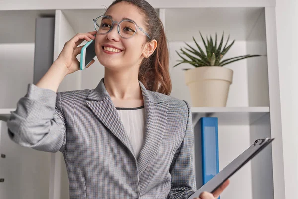 Lachende zakenvrouw praten op smartphone in Office — Stockfoto