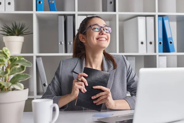 Femme formelle joyeuse avec journal intime dans le bureau — Photo