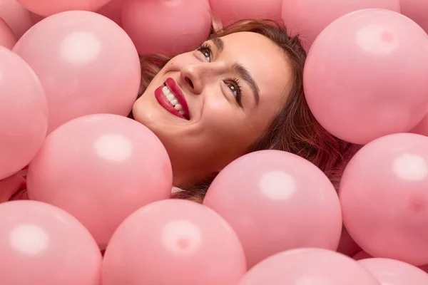 Веселая женщина, лежащая на воздушных шарах — стоковое фото