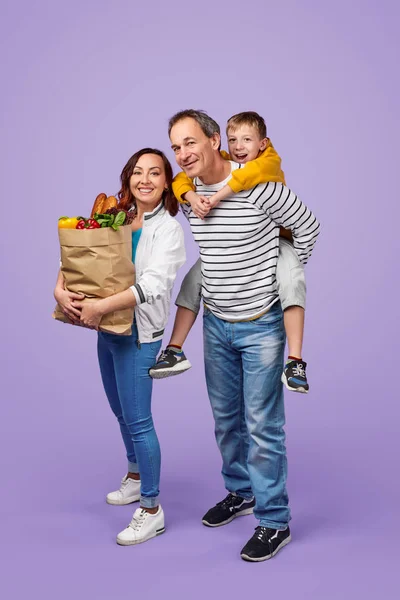 Wesoła rodzina z torbą artykułów spożywczych — Zdjęcie stockowe