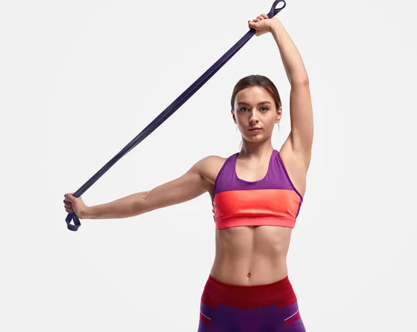 Muscular lady exercising with resistance band — Stock Photo, Image
