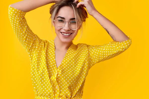 Fröhliche junge Frau, die Haare berührt — Stockfoto