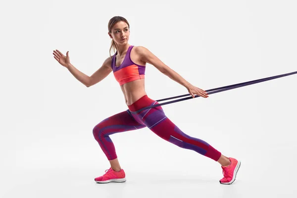 Sportswoman exercising with resistance rope and looking away — Stock Photo, Image