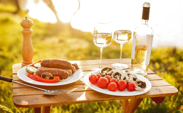 Алкоголь и еда для пикника на столе — стоковое фото