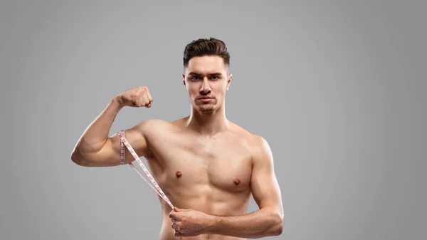 Allvarlig kille mäta armmuskler — Stockfoto