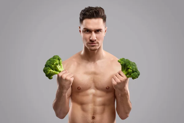 Uomo forte che tiene broccoli freschi — Foto Stock