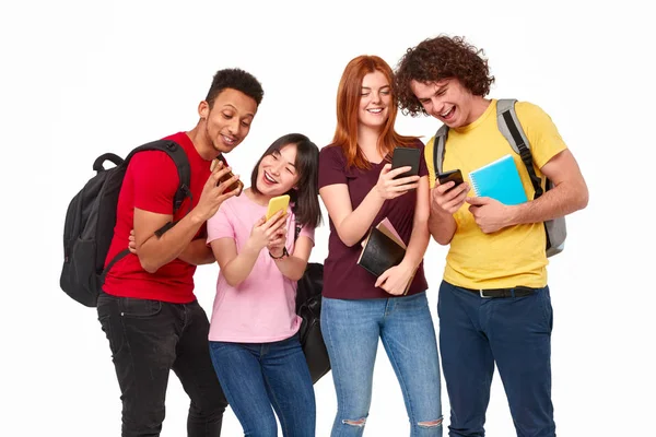 Estudantes multiétnicos alegres compartilhando smartphones — Fotografia de Stock