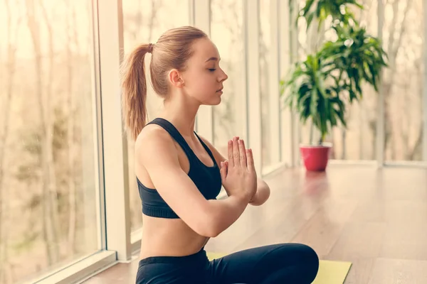 Ung kvinna mediterar i gymmet — Stockfoto