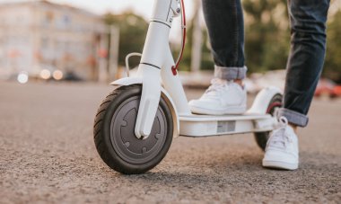 Sokakta elektrikli scooter üzerinde Kırpma bacaklar