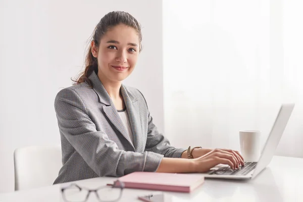 Young trainee met laptop in kantoor — Stockfoto