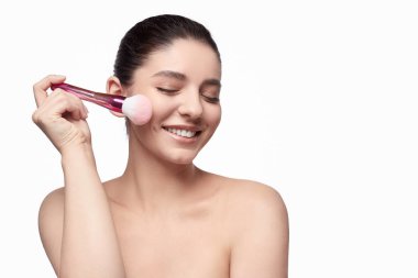 Yüz pudrası uygulayan neşeli model