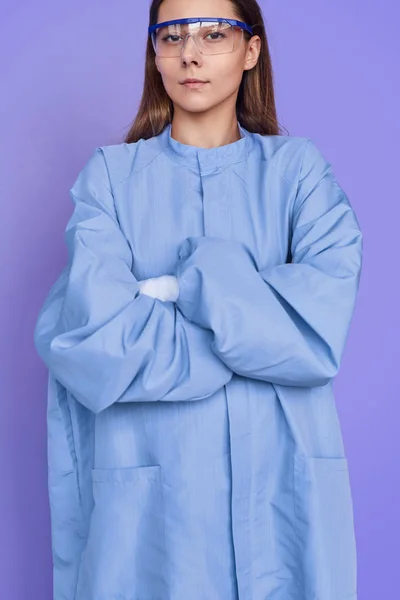 Serious young woman in blue uniform and glasses — Stock Photo, Image