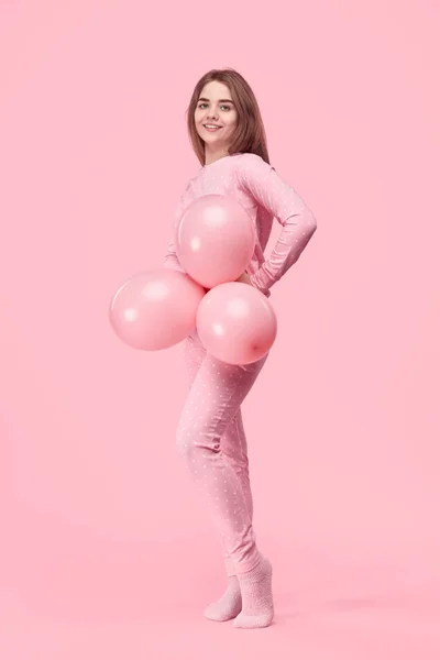 Teenager in pajama holding balloons — Stock Photo, Image