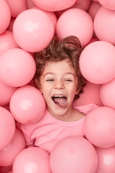 Kleiner Junge grimassiert unter Luftballons — Stockfoto