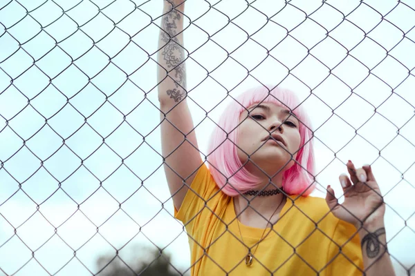 Trendy Asian teenager behind fence — Stock Photo, Image