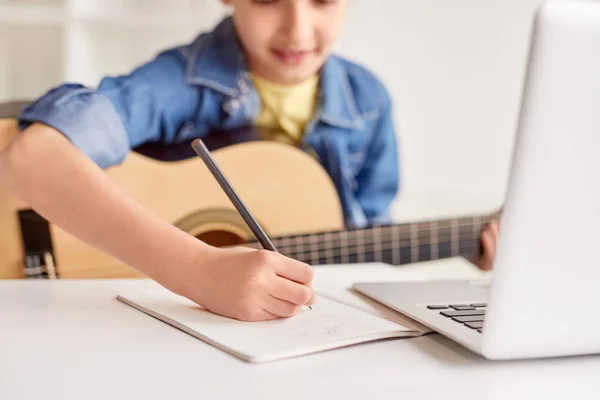 Chica tomando notas durante la lección de guitarra — Foto de Stock