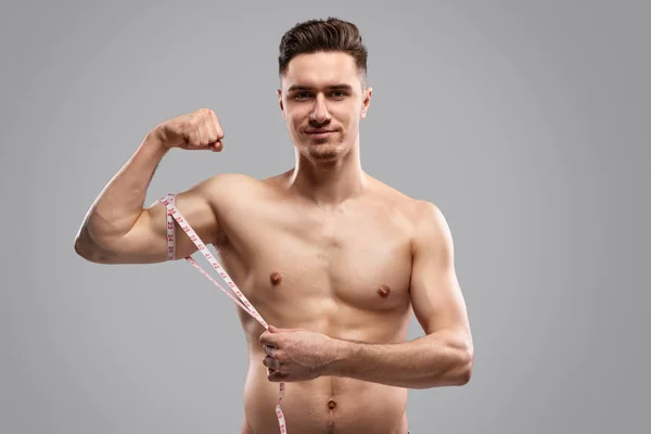 Sebevědomý sportovec měřící biceps — Stock fotografie
