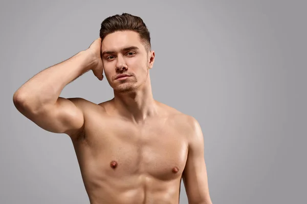 Apto jovem homem tocando o cabelo — Fotografia de Stock