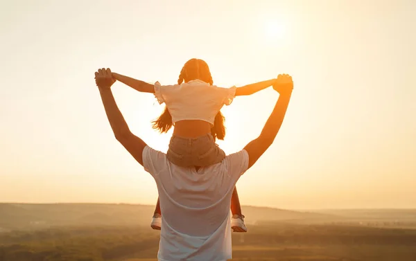 Pai e filha anônimos durante o pôr do sol — Fotografia de Stock