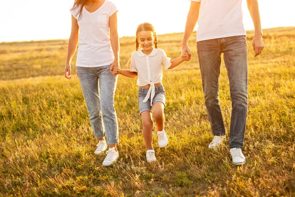 Glad dotter Walking med anonyma föräldrar i fält — Stockfoto