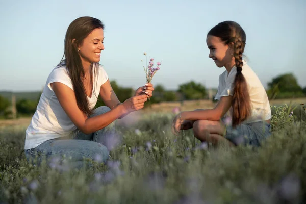 Matka a dcera sbírající květiny v terénu — Stock fotografie