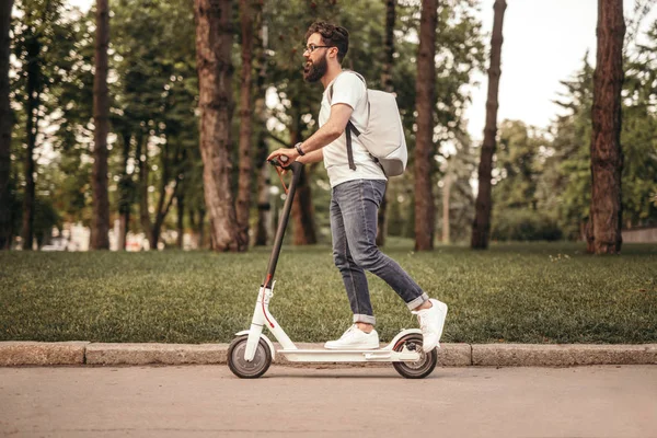 Der moderne Bürger fährt mit dem Öko-Elektroroller auf dem Bürgersteig — Stockfoto