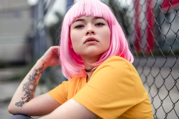 Ganska ung asiatisk kvinna med rosa hår och tatuering — Stockfoto