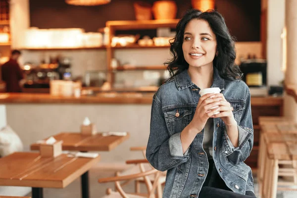 Θετική περιστασιακή γυναίκα πίνοντας καφέ μόνο στο καφέ — Φωτογραφία Αρχείου