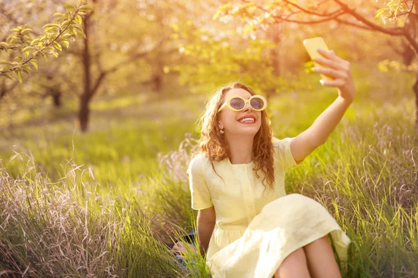 Femeia modernă veselă face selfie în timp ce se relaxează pe iarbă — Fotografie, imagine de stoc