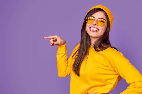 Mulher elegante alegre apontando para o lado — Fotografia de Stock