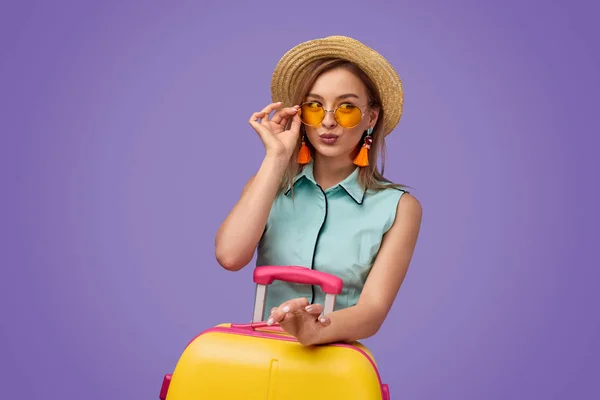 Viajero joven de moda con maleta haciendo pucheros labios — Foto de Stock