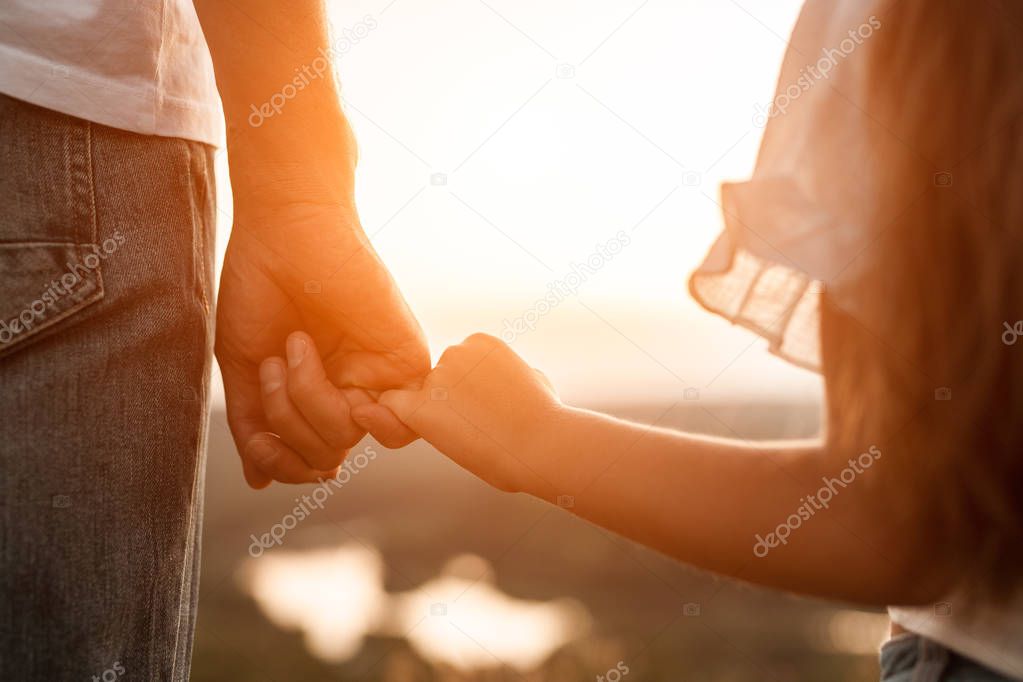 Happy father and daughter holding hands together