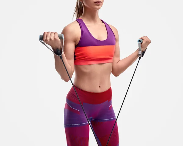 Crop sportswoman exercising with rubber band — Stock Photo, Image