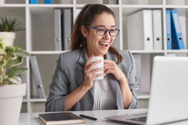 Employé excité avec tasse en utilisant un ordinateur portable — Photo