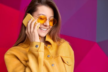 Akıllı telefonda konuşan güneş gözlüğü mutlu trendy kadın
