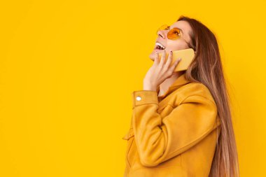 Heyecanlı genç kadın akıllı telefonda konuşuyor