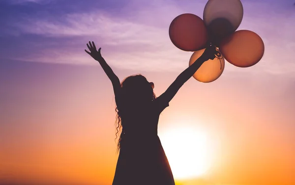 Upphetsad Lady med ballonger titta på solnedgången — Stockfoto