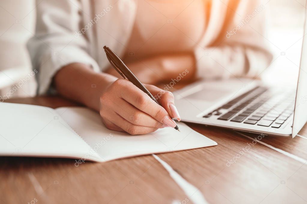 Freelance woman planning while working on laptop in coffee shop