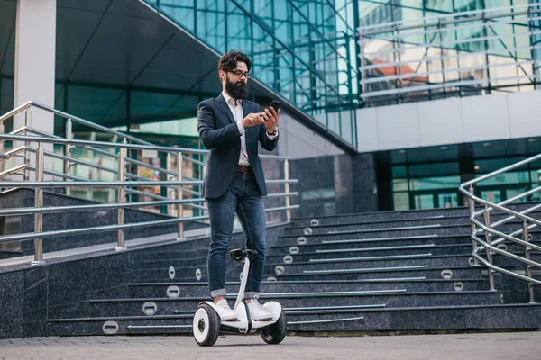 Pracownik biurowy na gyroscooter za pomocą smartfona — Zdjęcie stockowe