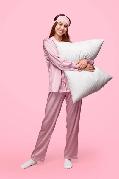 陽気な若い女性は枕を抱きしめる — ストック写真