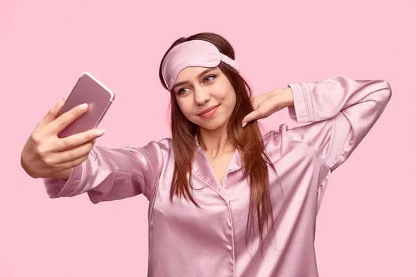 Jonge vrouw in nachtkleding nemen selfie — Stockfoto