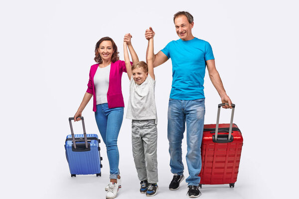 Cheerful family with suitcases ready for trip