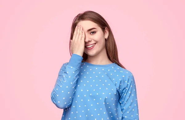 Adolescente alegre em pijama cobrindo olho — Fotografia de Stock