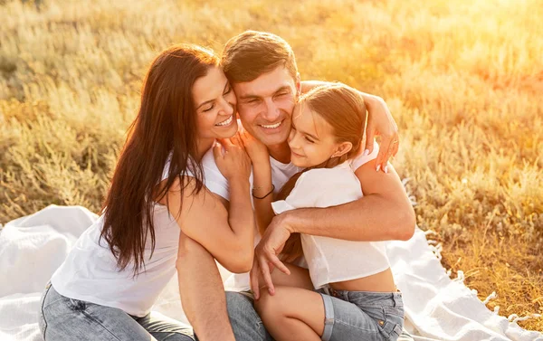 Familia alegre abrazándose en el campo —  Fotos de Stock