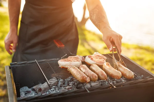 Coltivatore che cucina carne in campagna — Foto Stock