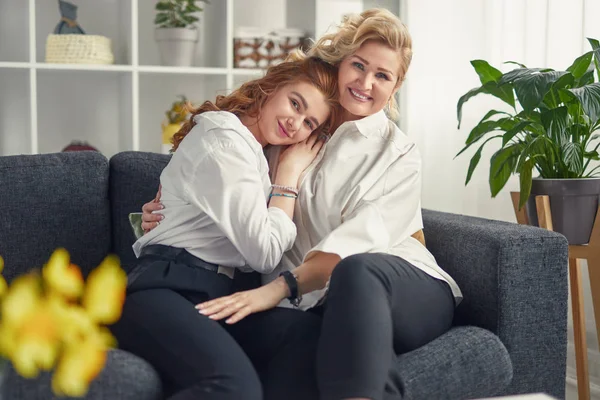 Gelukkig moeder en dochter knuffelen op de Bank — Stockfoto